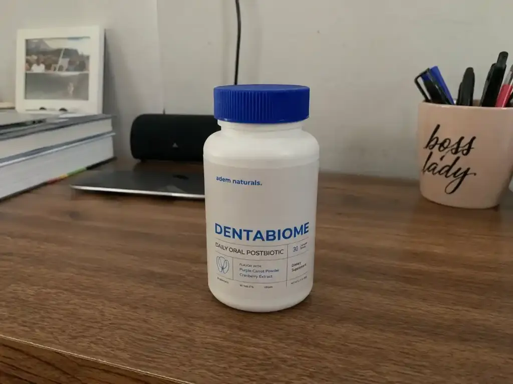 DentaBiome daily oral postbiotic supplement bottle on a wooden desk at home
