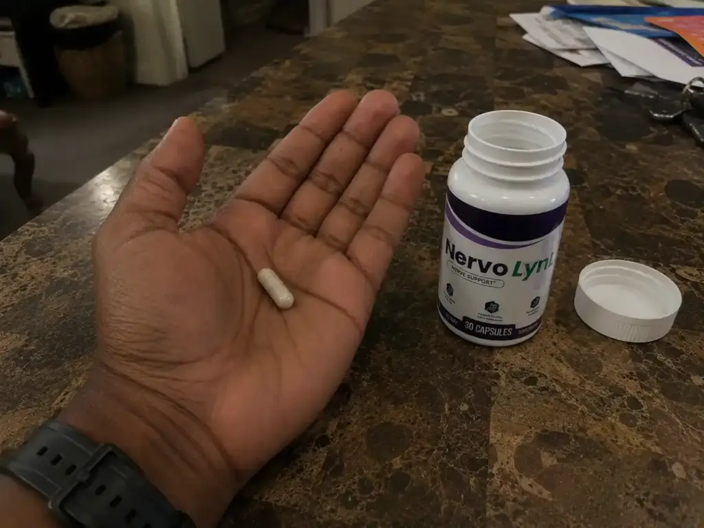 NervoLyn supplement capsule held in hand beside an open NervoLyn bottle