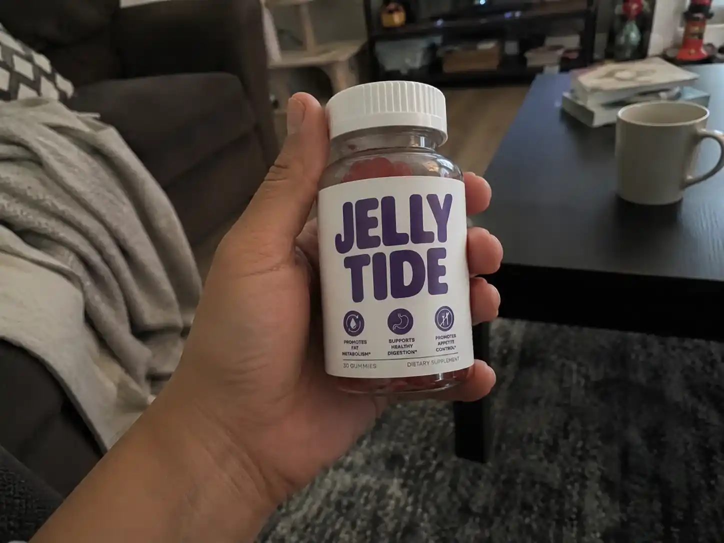 Hand holding Jelly Tide gummies bottle