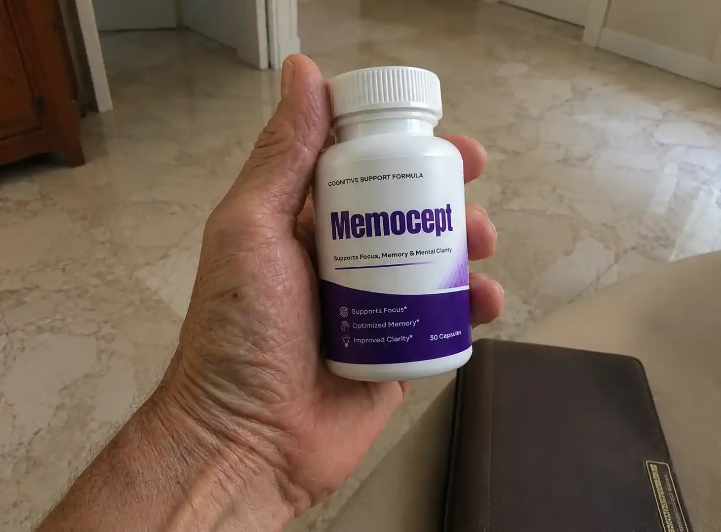 Hand holding Memocept supplement bottle
