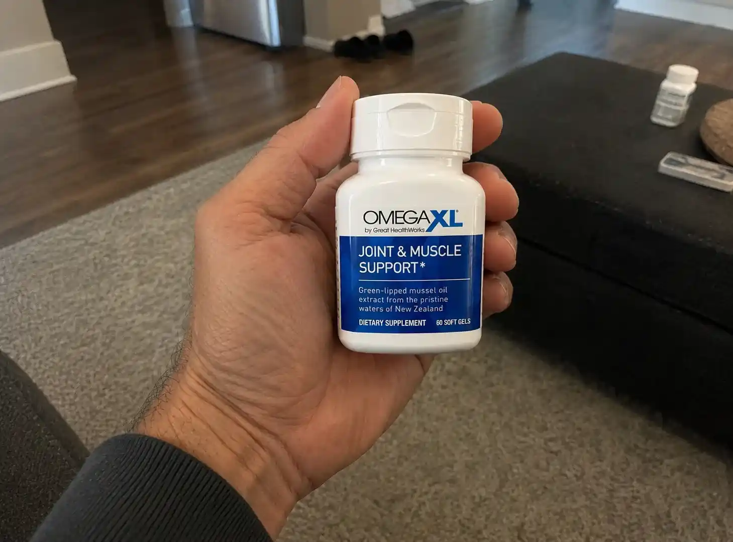 Hand holding Omega XL joint support bottle