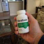 Hand holding Vitrafoxin supplement bottle