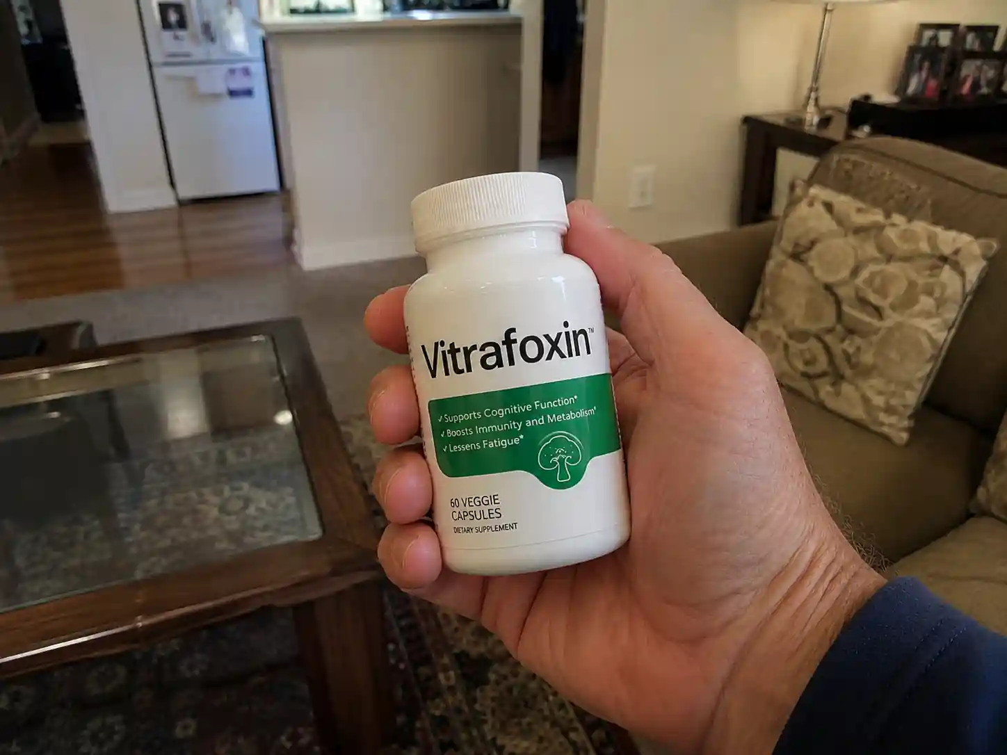 Hand holding Vitrafoxin supplement bottle