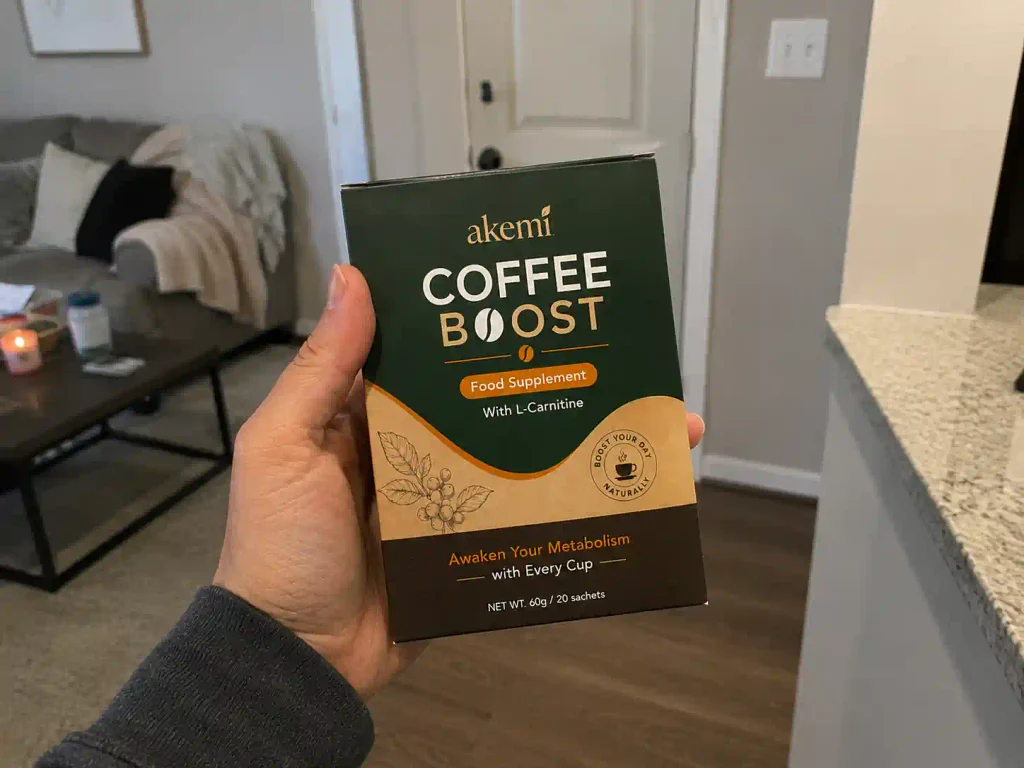 hand holdingAkemi Coffee Boost weight management supplement box.
