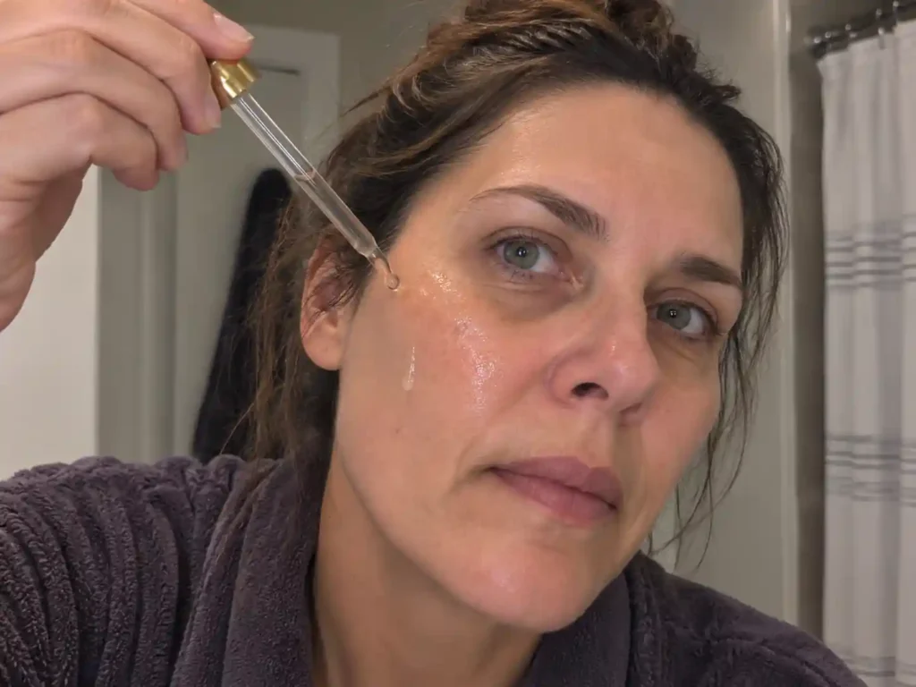 woman applying GloraMD wrinkle serum on face
