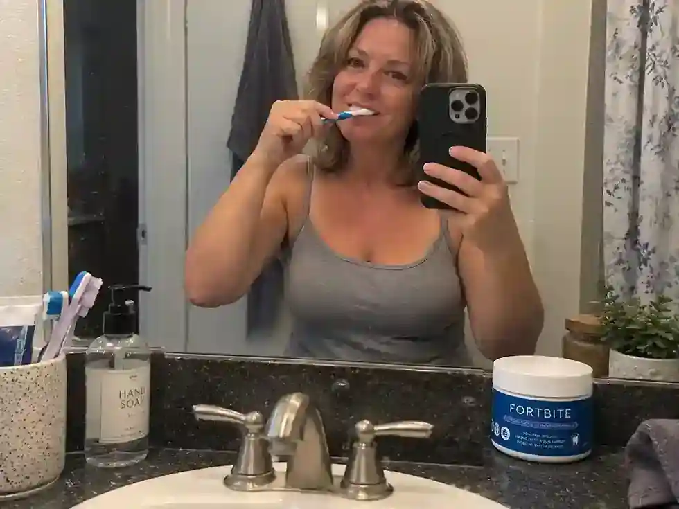 woman brushing teeth with fortbite dental pwder